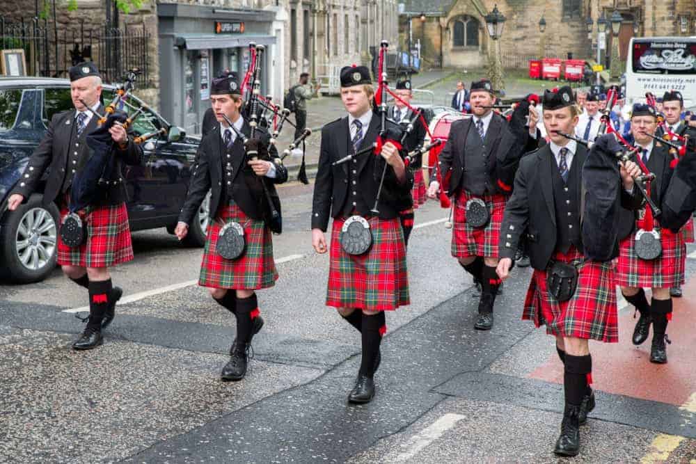 Ceremonial march of orchestra with bagpipes and kilts.