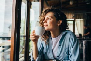 Woman drinking coffee by a window