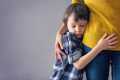 Boy in a plaid shirt hugging his mother's waist