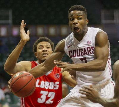 Washington State guard Ike Iroegbu (2) passes off the basketball while being defended by New Mexico forward Tim Williams (32) in the second half of an NCAA college basketball game at the Diamond Head Classic, Friday, Dec. 25, 2015, in Honolulu. Washington State won 82-59.  (EUGENE TANNER / ASSOCIATED PRESS)