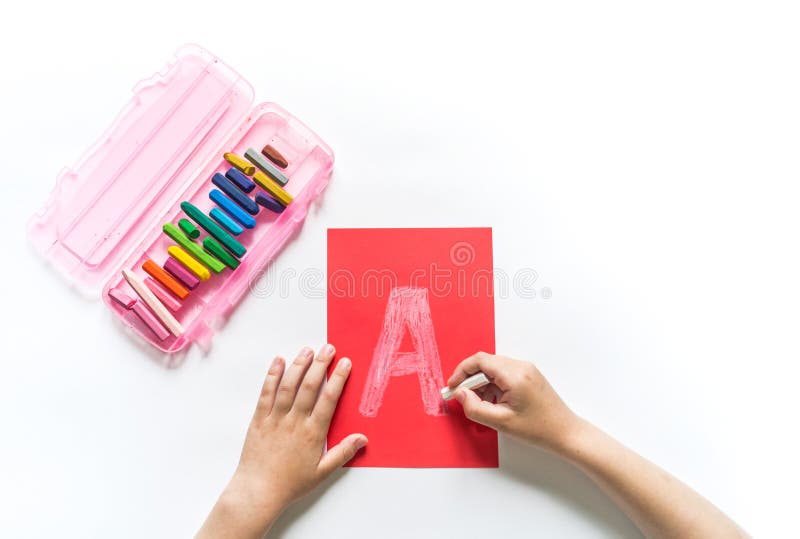 Children`s hands write the letter A chalk