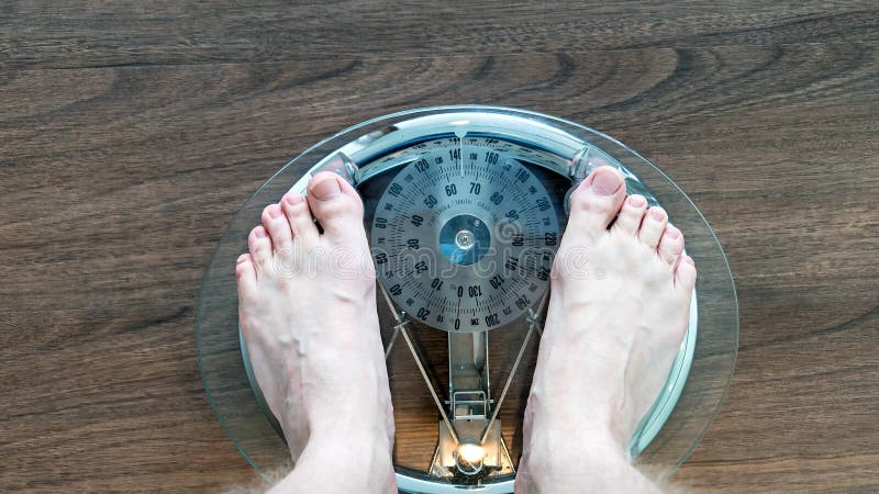 Feet of a Young Man Measuring His Weight on a Scale Stock Image - Image ...