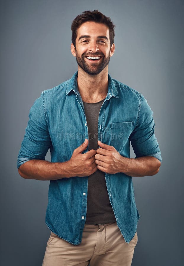 Making casual look as cool as ever. Studio shot of a handsome and happy young man posing against a grey background. royalty free stock photo