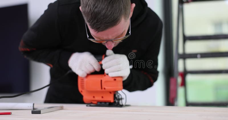 Carpenter in Gloves Cuts Wood Panel Using Jigsaw at Workshop Stock ...