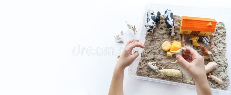 Montessori material. Children`s hands play an animal figure. Kinetic sand. Copy space