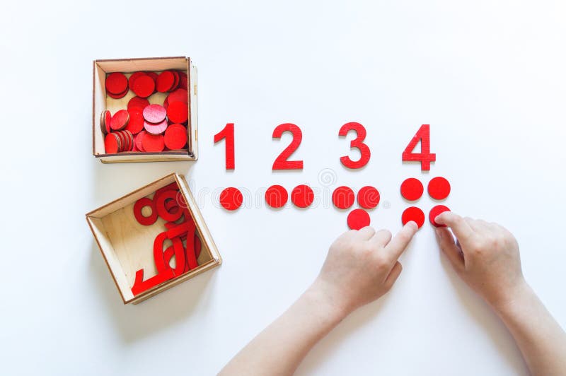 Montessori material. Children`s hands. The study of mathematics