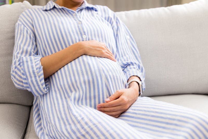 Pregnant Woman Hold with Her Belly and Sit on Sofa at Home Stock Image ...