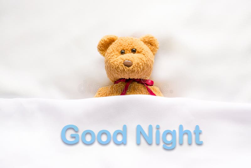 Teddy Bear lying in the white bed with message ' Good night ' royalty free stock photos