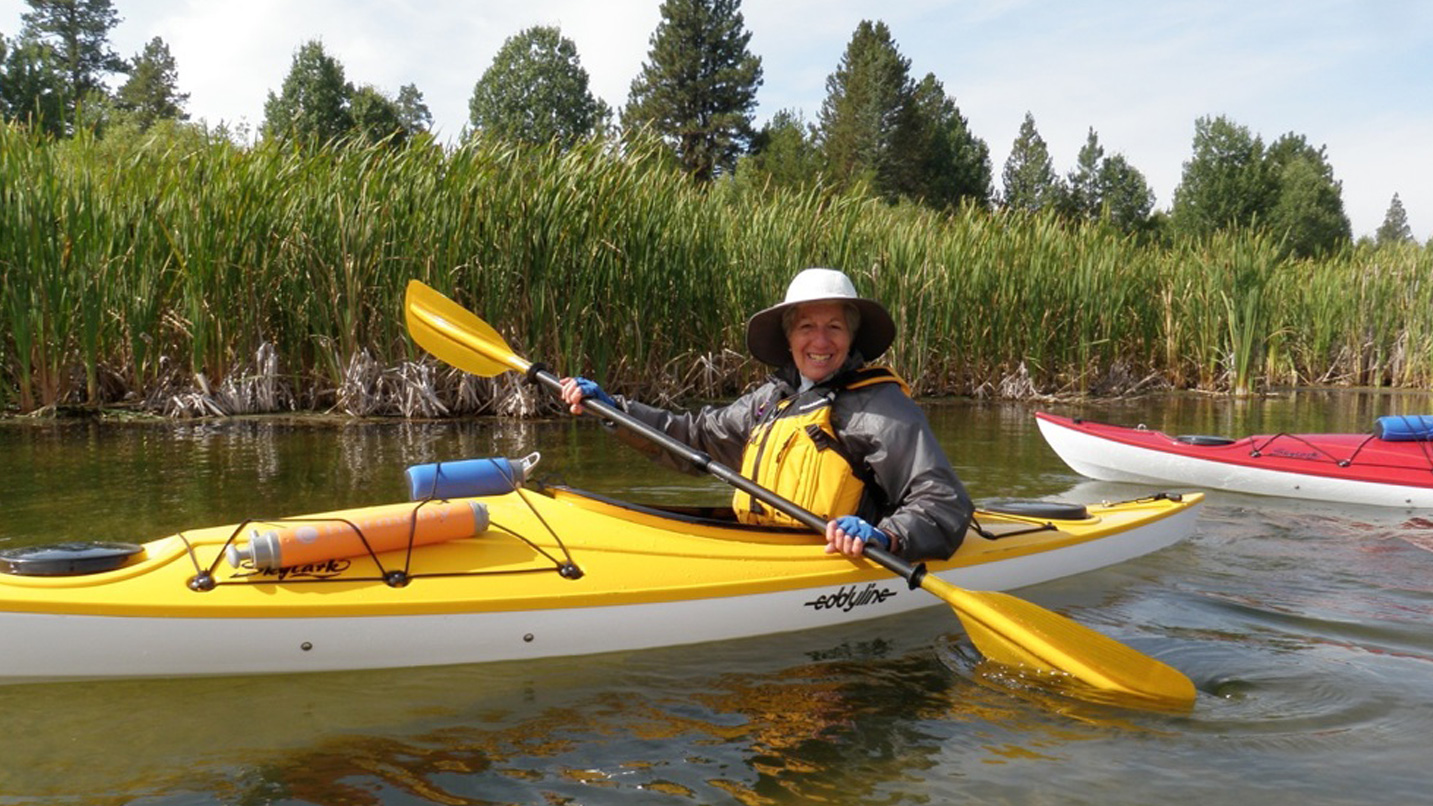 A woman kayaks down a river