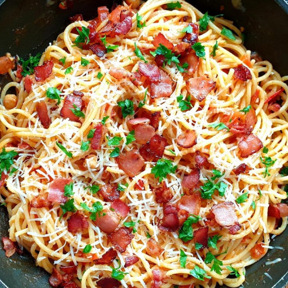 spaghetti with crispy bacon in a skillet