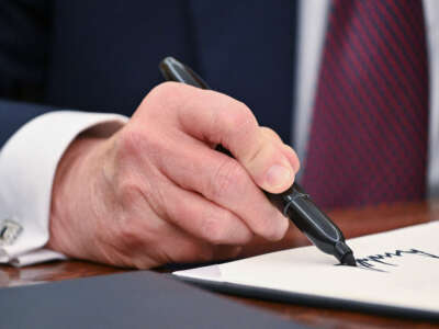 President Donald Trump signs an executive order in the Oval Office of the White House in Washington, D.C., on January 23, 2025.