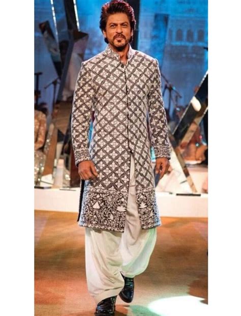 a man in an ethnic outfit walking down the runway