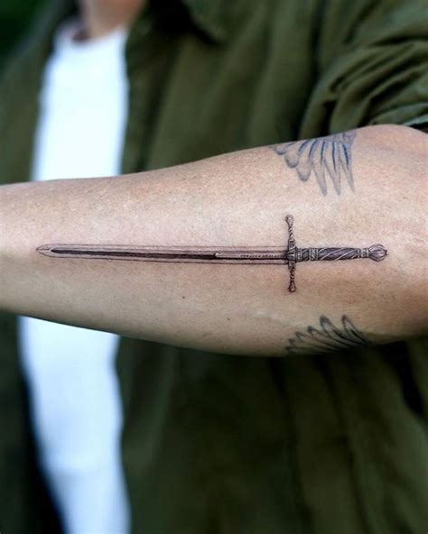 Micro-realistic style sword tattooed on the forearm.