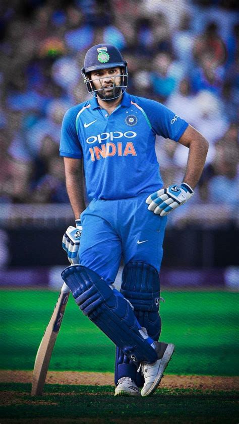 a man in blue uniform holding a cricket bat