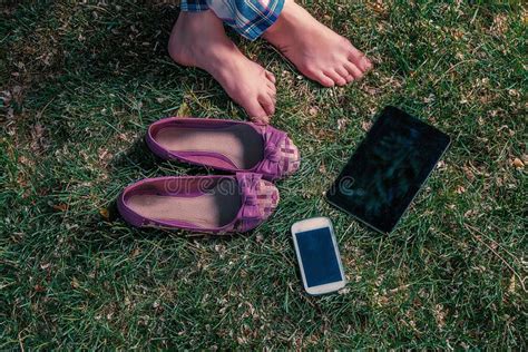 Barefoot Girl Sitting on Grass with Tablet-pc and Smartphone Stock ...