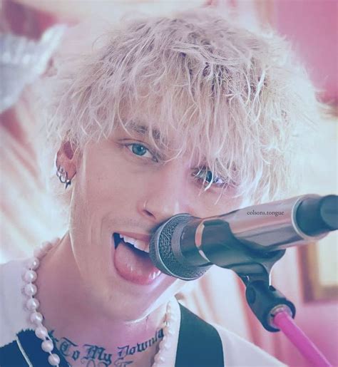 a young man with blonde hair and piercings on his neck singing into a ...