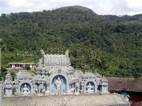 an ornate building with statues on the roof and trees in the backgrouds