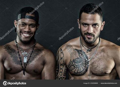 Fashion models smiling African man and tattooed Caucasian guy ...