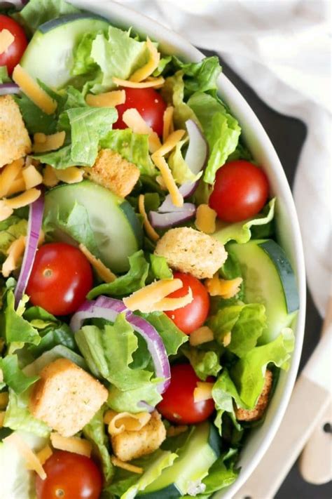 A classic house salad featuring crisp lettuce, tomatoes, croutons ...