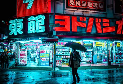 Man holding umbrella walking on the street near store during nighttime ...