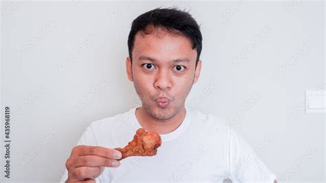 Young Asian man is eating fried chicken wear white shirt Stock Photo ...