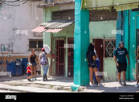 Cuban people lifestyle by buildings with metal grates in doors and ...