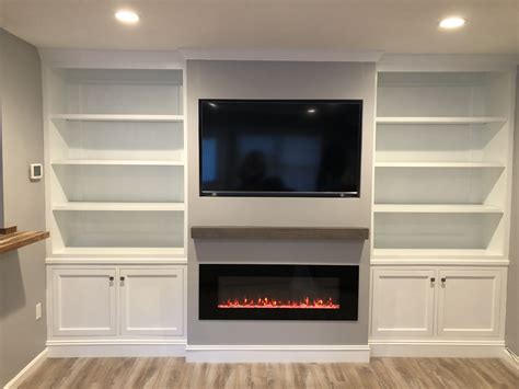 Custom built in shelves and cabinetry with rustic mantle, mounted flat ...