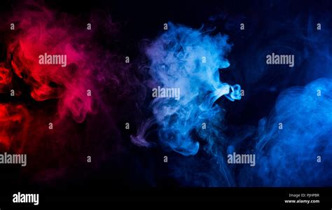 abstract shapes of mixed colors of blue and red smoke at dark ...