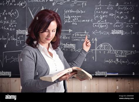 Teacher Pointing At Blackboard While Holding Book Stock Photo - Alamy