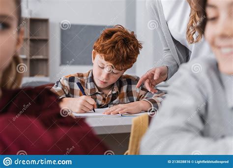 Teacher Pointing with Finger Near Redhead Stock Photo - Image of study ...