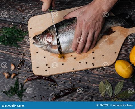 Man Cuts a Trout with a Knife on a Board. Fresh Raw Fish Stock Image ...