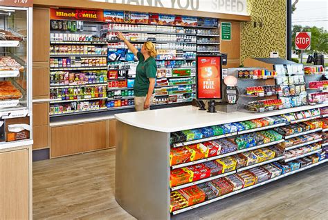 a woman is standing at the cash register in a grocery store with her ...