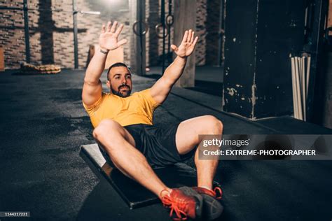 Active Young Athlete Doing A Butterfly Sit Ups Exercise In A Gym Gym ...