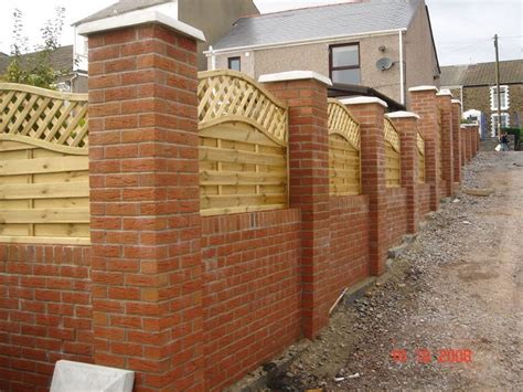 Garden wall with brick pillars and decorative wooden fencing | Brick ...