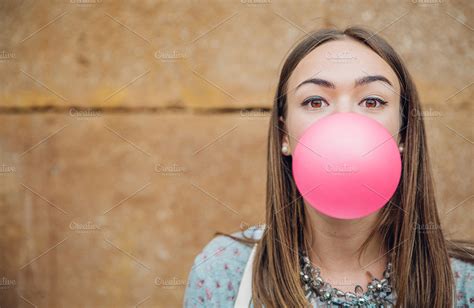 Young girl blowing pink bubble gum | High-Quality People Images ...