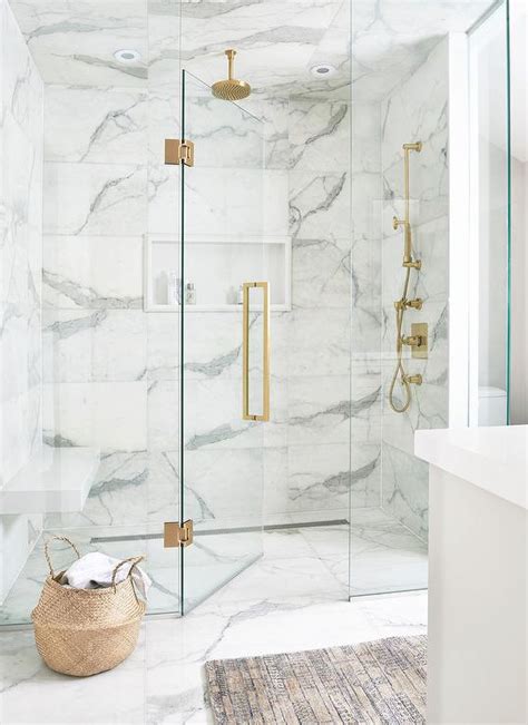 Luxurious white and gray marble shower with a white niche enclosed with ...