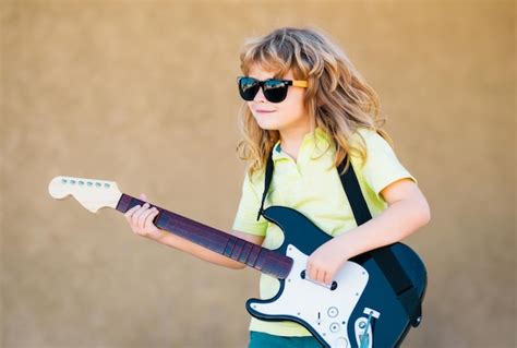 Premium Photo | Boy with guitar child plays a guitar and sings kids ...