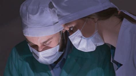 Doctors surgeons operate patient in operating theater, tilt down ...