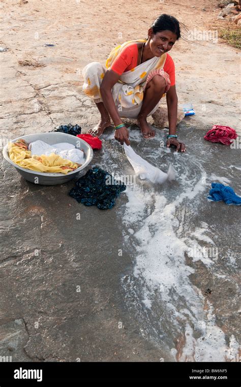 Indian woman washing clothes by hand next to a river. Andhra Pradesh ...