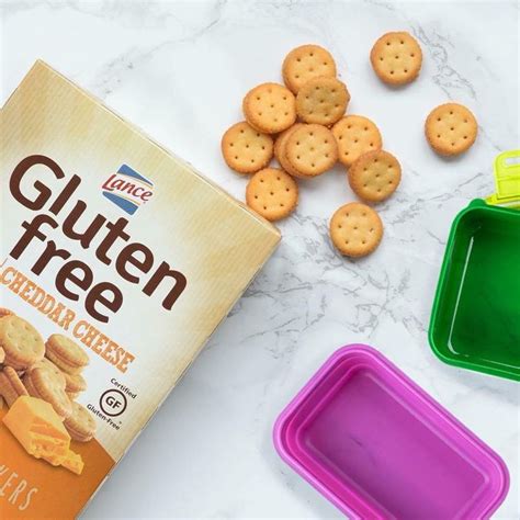 a box of gluten free cheddar cheese crackers next to other snacks