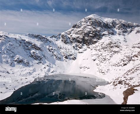 Snowdon in winter conditions: the summit, Yr Wyddfa, rises over Glaslyn ...