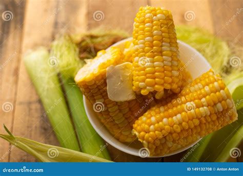 Boiled Corn Cob in a Plate with Butter, on Wooden Textures and Green ...