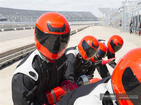 Pit crew wearing helmets in sunny pit lane — sports, fuel - Stock Photo ...