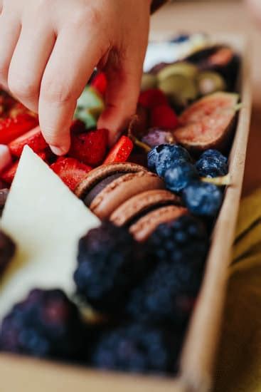 Hand Grabbing Food From Charcuterie Board - Photos by Canva