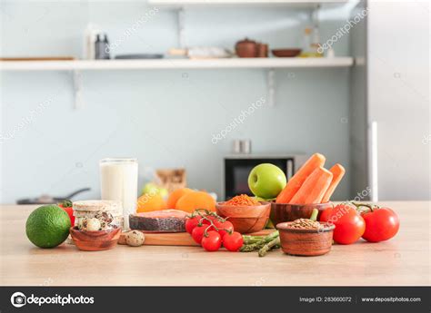 Different Healthy Food On Table In Kitchen Stock Photo By ©serezniy