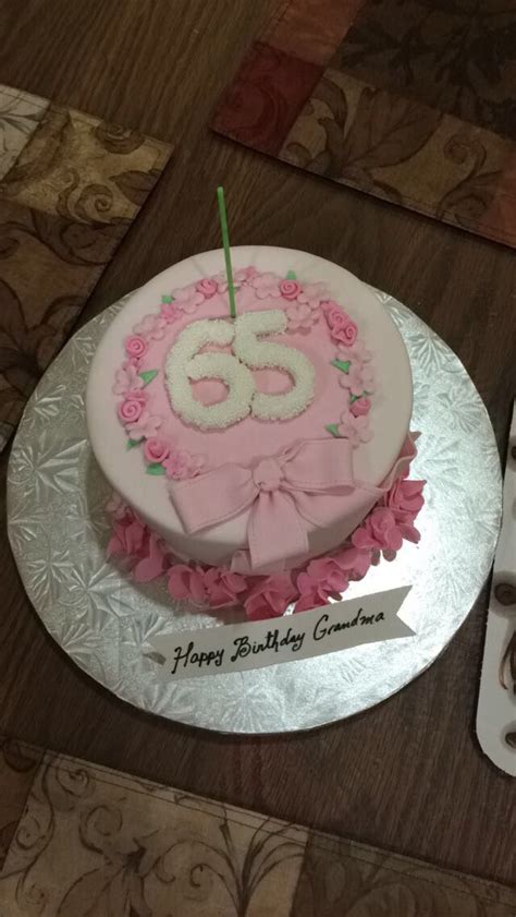 a pink and white birthday cake with the number 55 on it sitting on a table