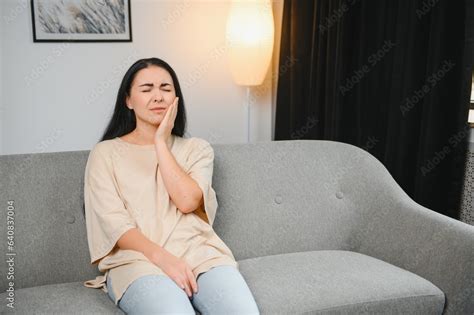 Woman with severe toothache touching her swollen cheek. Young girl ...