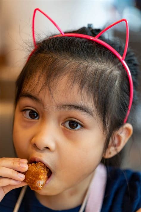 Asian Girl Eating Chicken. Child Eating a Chicken Nuggets Stock Image ...