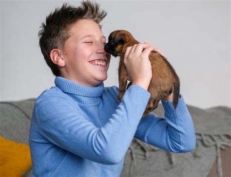 Niño jugando con un perro bebé. los niños juegan con cachorros en casa ...