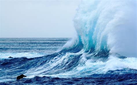 a large wave is crashing into the ocean